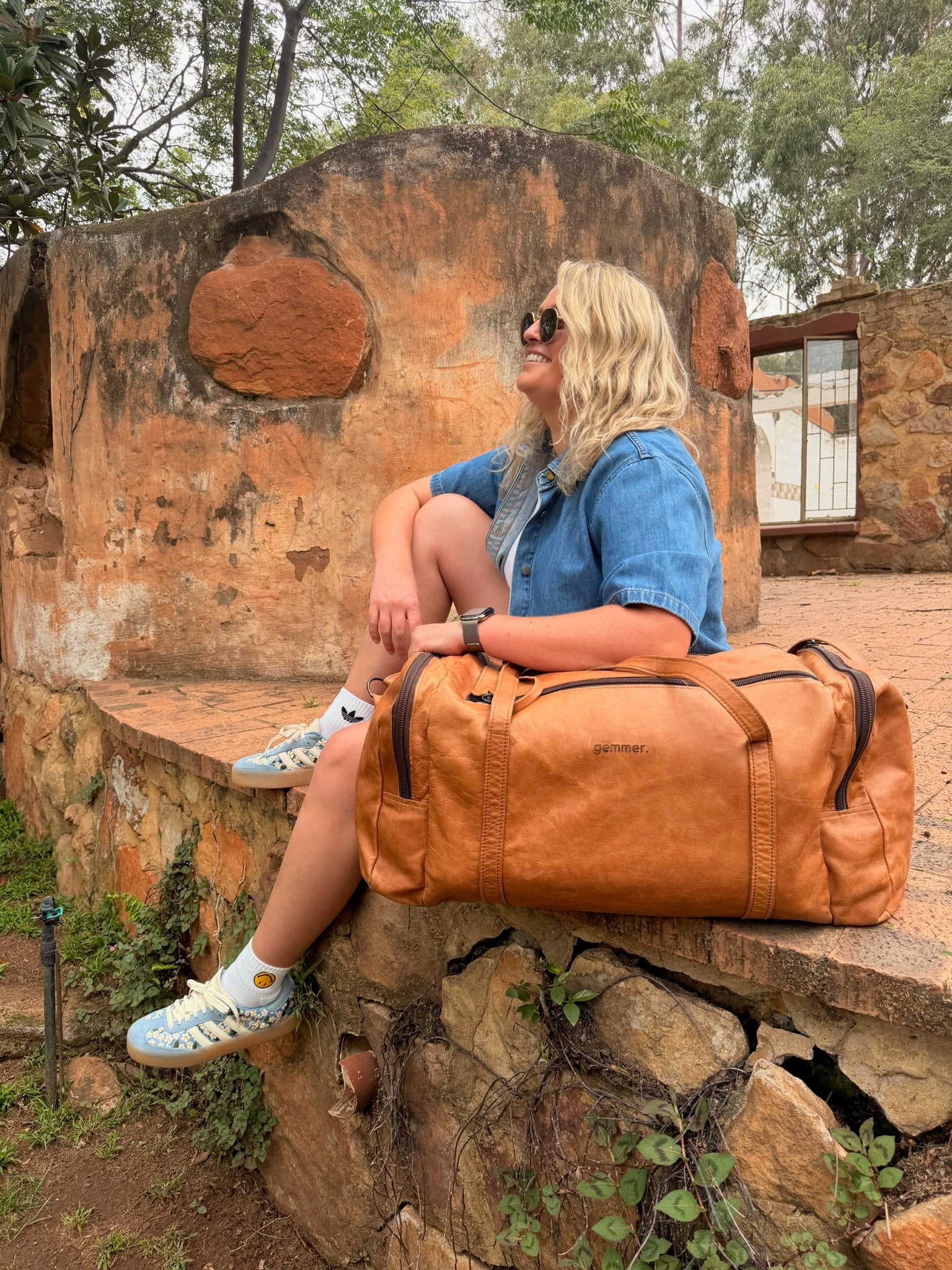 TRVL Duffel Bag Large – Lifestyle Photo – Lady Carrying Toffee Leather Bag